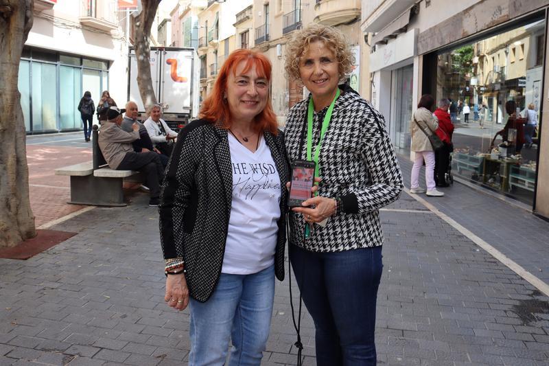 Montse Martin i Maria Montserrat ensenyant el cartell de la 3a edició de la Fira de Salut Counitària del Vendrell